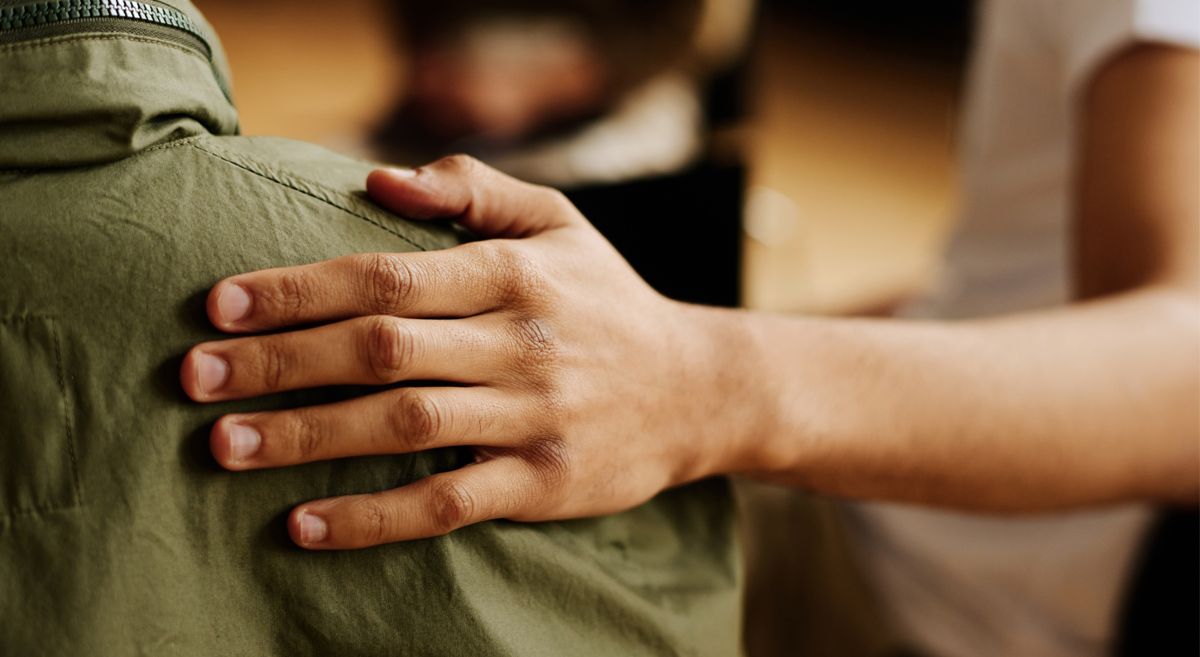 Picture of a hand on someone's shoulder.